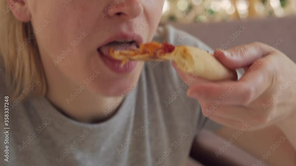 Close-up of a woman eating pizza outside on a Sunny summer day Close-up of a woman eating pizza outside on a Sunny summer day