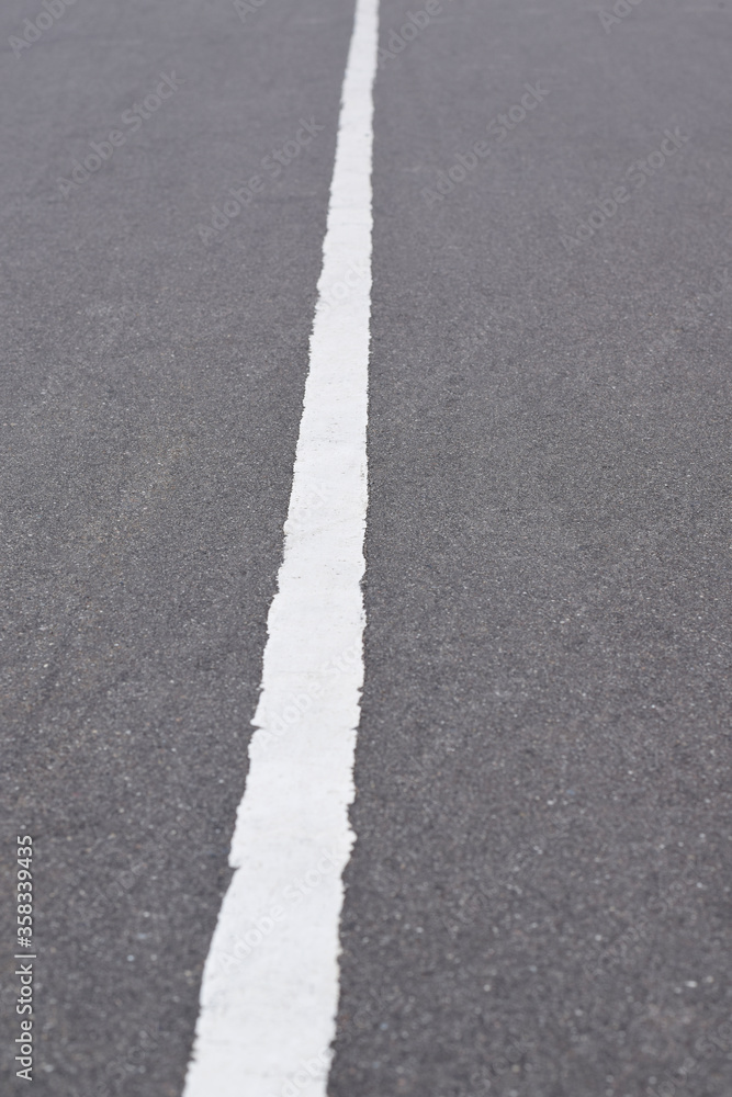 White solid line on asphalt road. Carriageway marking