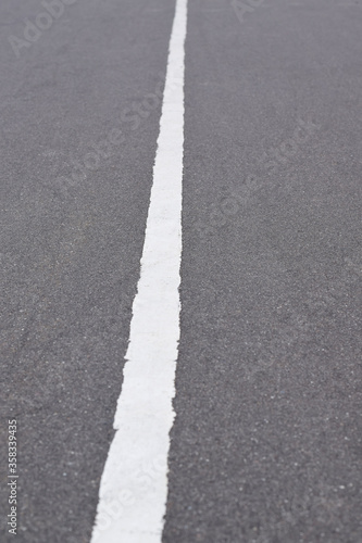 White solid line on asphalt road. Carriageway marking
