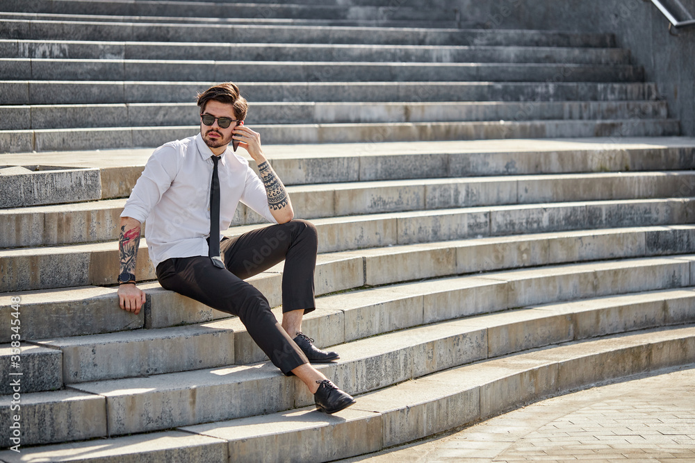 Handsome businessman making a phone call or using a phone outside Handsome businessman making a phone call or using a phone outside
