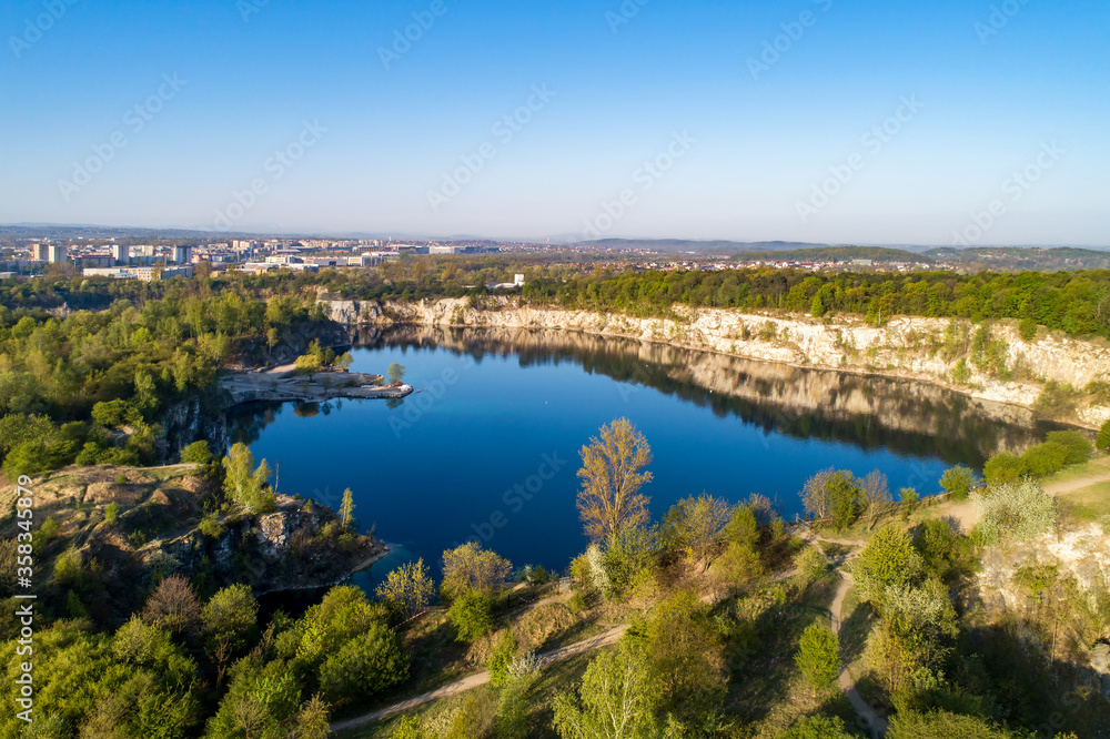 Krakow, Poland. Zakrzowek lake with steep cliffs in place of former flooded limestone quarry in Twardowski Rocks. Popular recreational place. Aerial view at sunrise