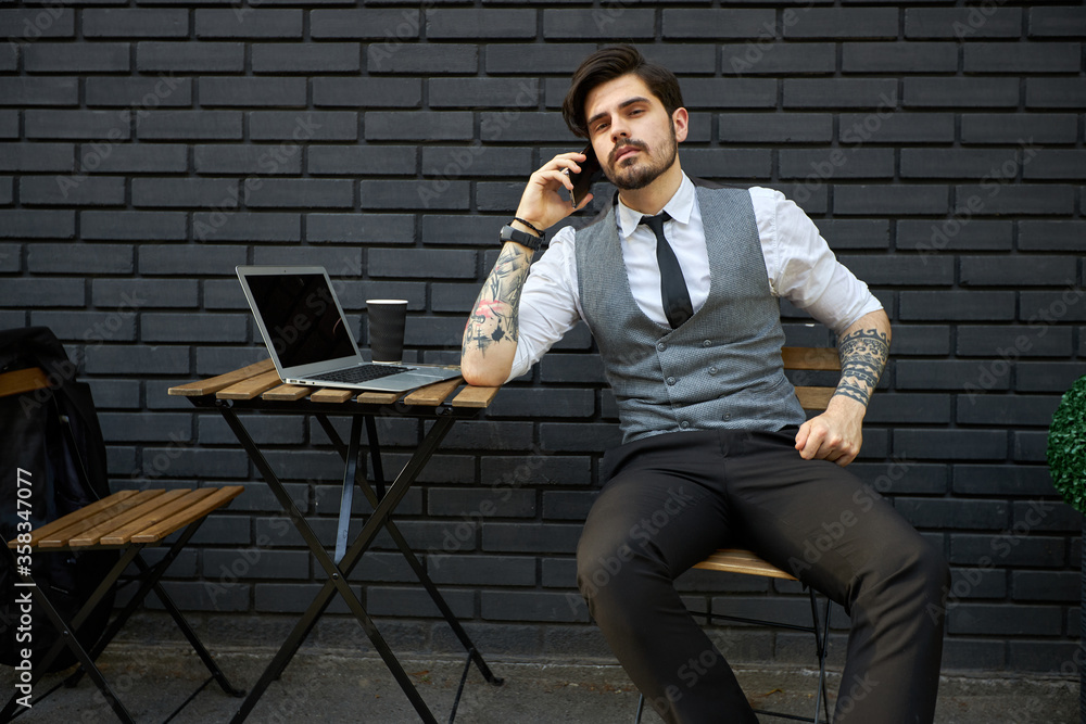 Handsome businessman making a phone call or using a phone outside Handsome businessman making a phone call or using a phone outside