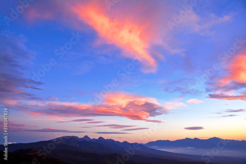                                                                                                 The Yatsugatake mountain range that is illuminated by the setting sun during the magic hour.