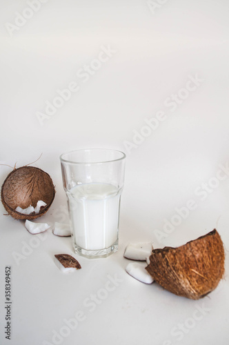 Glass with coconut milk. Chopped coconut. White background.