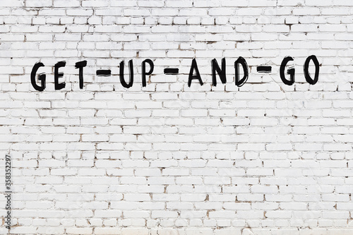 White wall with black paint inscription get-up-and-go on it
