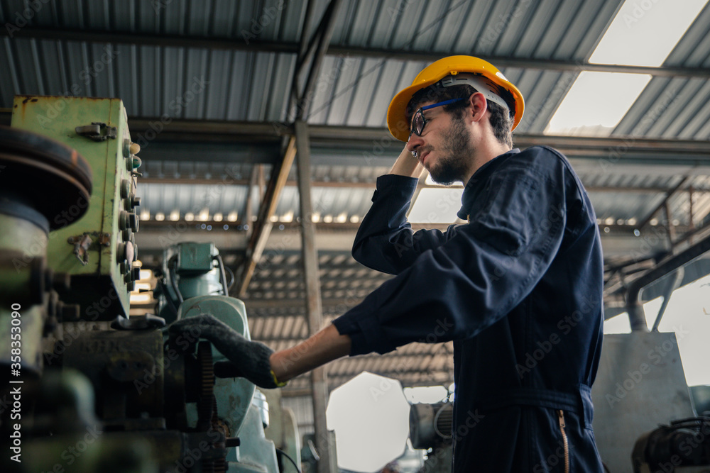 Industry factory maintenance engineer wearing uniform and safety helmet under inspection and checking production process on factory station on machinery. Industry, Engineer, construction concept. Industry factory maintenance engineer wearing uniform and safety helmet under inspection and checking production process on factory station on machinery. Industry, Engineer, construction concept.