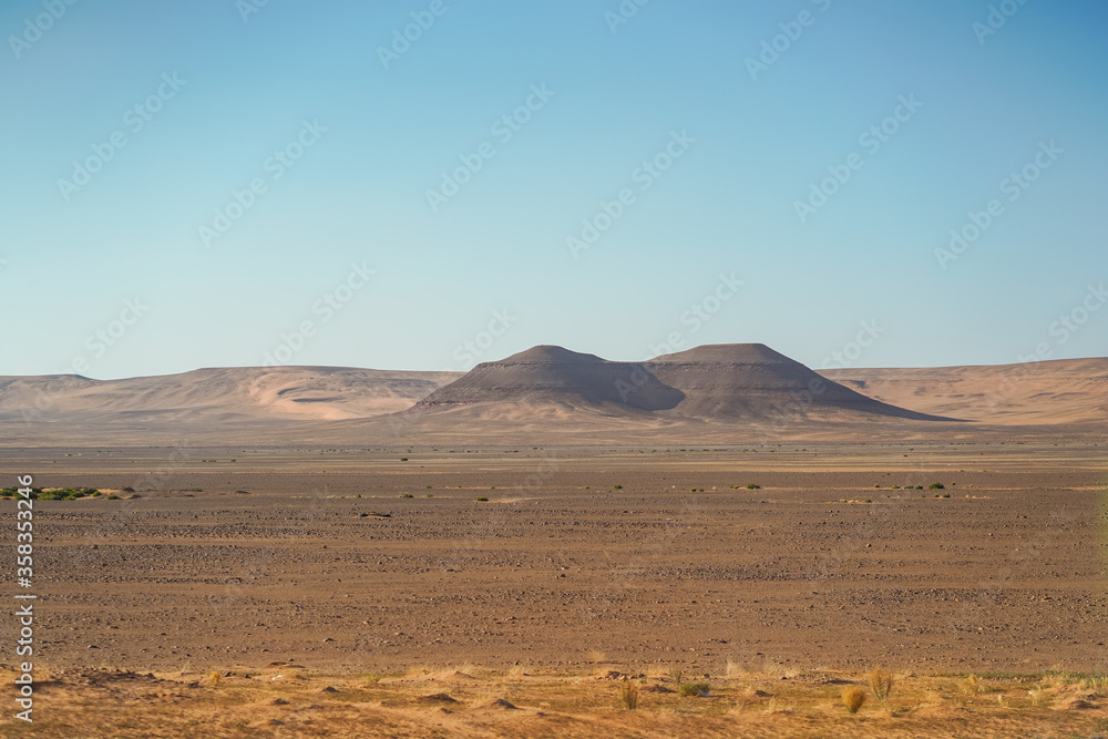 bleak desert landscape with mountain and rock formations