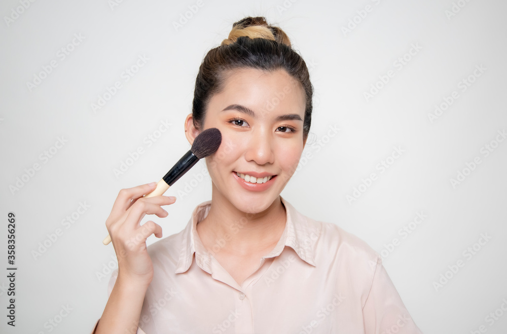 Asian women are using a make-up brush.