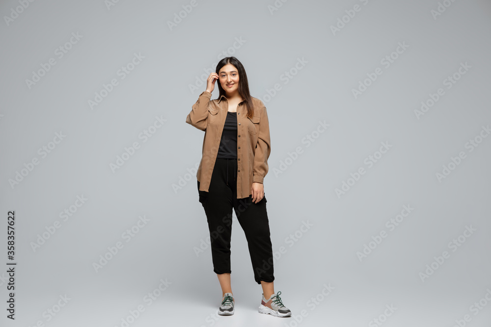 Fashionable, stylish. Young woman in casual wear on gray background. Bodypositive character, feminism, loving herself, beauty concept. Plus size businesswoman, beautiful girl. Inclusion, diversity. Fashionable, stylish. Young woman in casual wear on gray background. Bodypositive character, feminism, loving herself, beauty concept. Plus size businesswoman, beautiful girl. Inclusion, diversity.