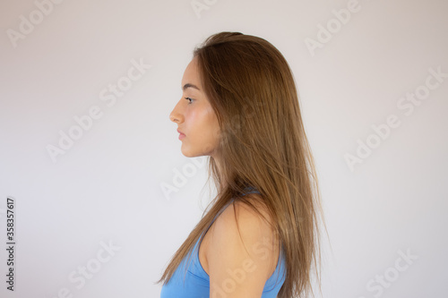 Profile portrait of a pretty young girl in blue shirt