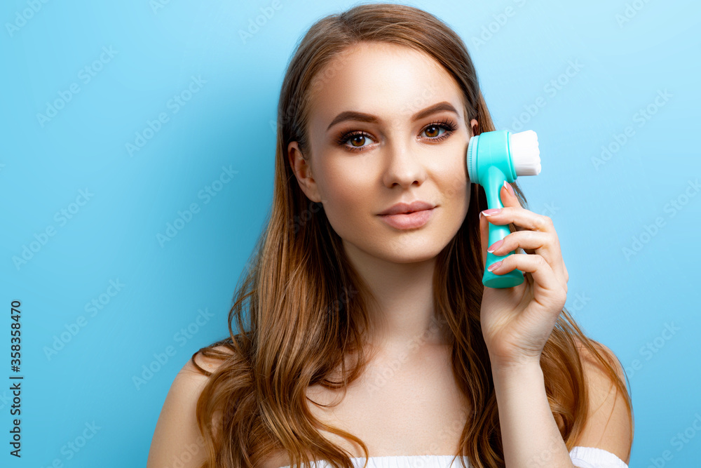 Girl with a face brush on a blue background Girl with a face brush on a blue background