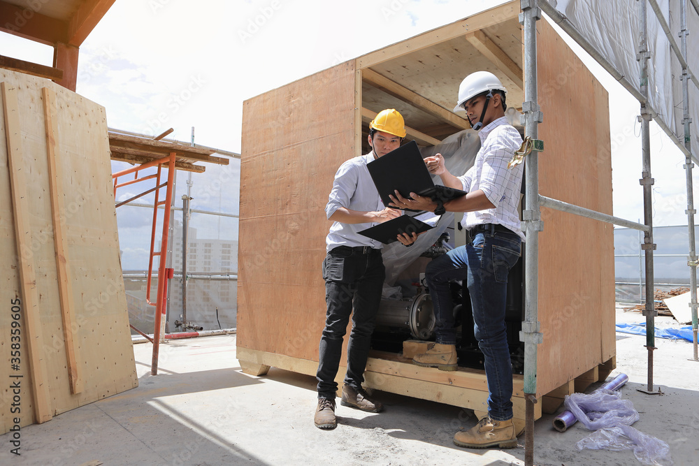 Fototapeta premium Two engineers are inspecting the machines in the container to make sure they meet the specifications before they are installed.