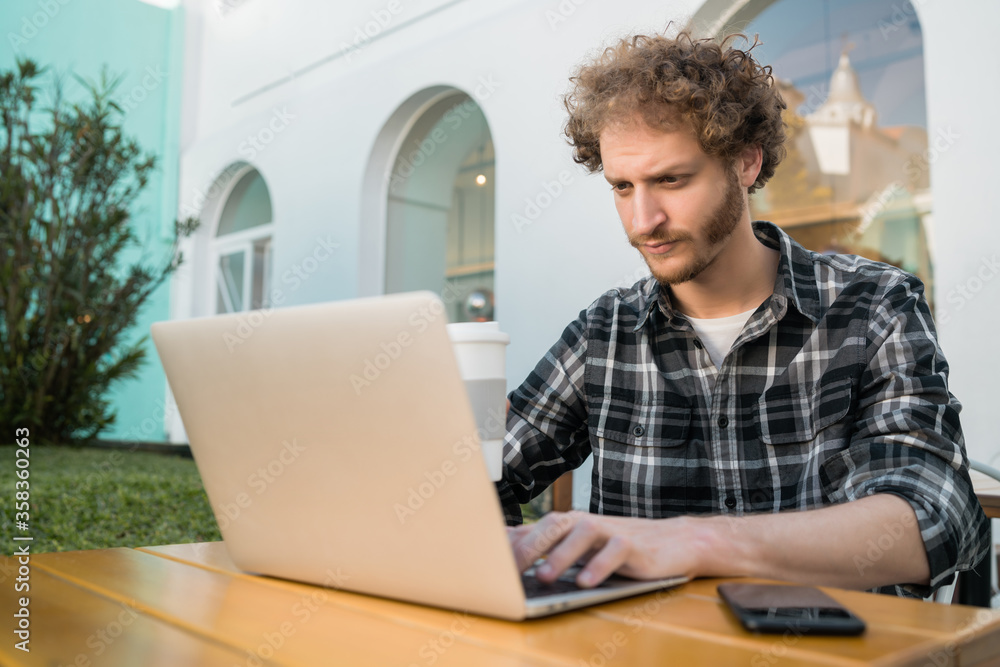 Young man using his laptop in a coffee shop. Young man using his laptop in a coffee shop.