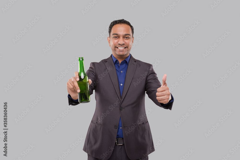Businessman Holding Beer Bottle Showing Thumb Up. Indian Business man With Beer bottle in Hand. Businessman Holding Beer Bottle Showing Thumb Up. Indian Business man With Beer bottle in Hand.