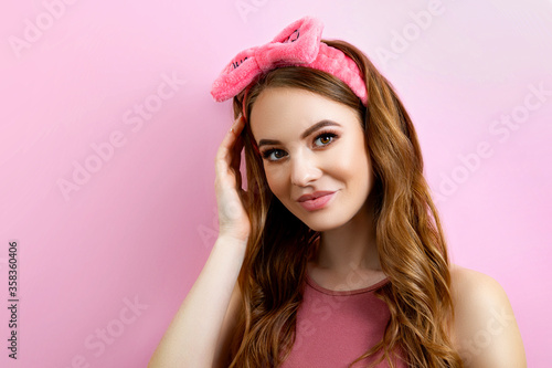 Studio portrait of a young woman on a pink background