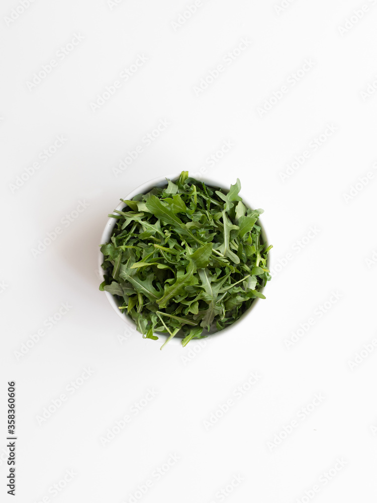 bowl of arugula salad, fresh and healthy greens, top view bowl of arugula salad, fresh and healthy greens, top view