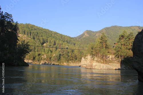 wide river flows on the background of the misty mountains