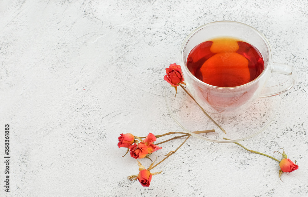 glass cup of tea and roses on textured background with copy spce glass cup of tea and roses on textured background with copy spce