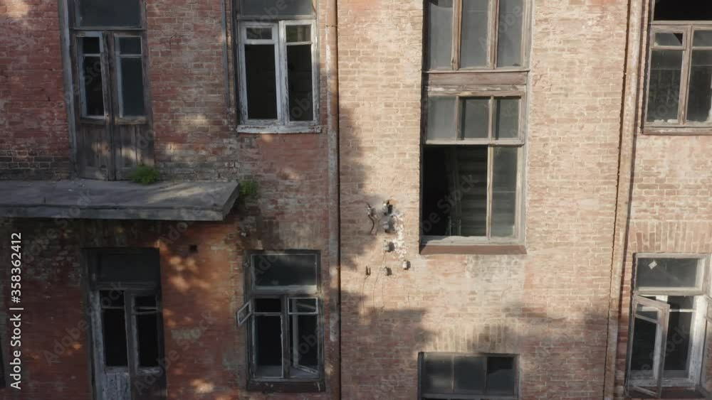 Abandoned early 20th century apartment house (multi-story building) with broken windows and balconies. Aerial view Abandoned early 20th century apartment house (multi-story building) with broken windows and balconies. Aerial view