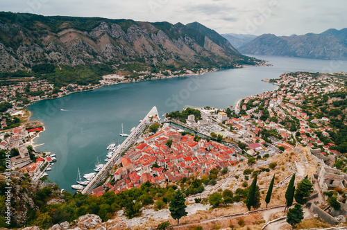 Landscape in Montenegro.  .Bird's eye view of Boko-Kotor Bay. In the photo - old masonry buildings, cherished roofs, sharp roof spiers against the backdrop of green mountains  photo