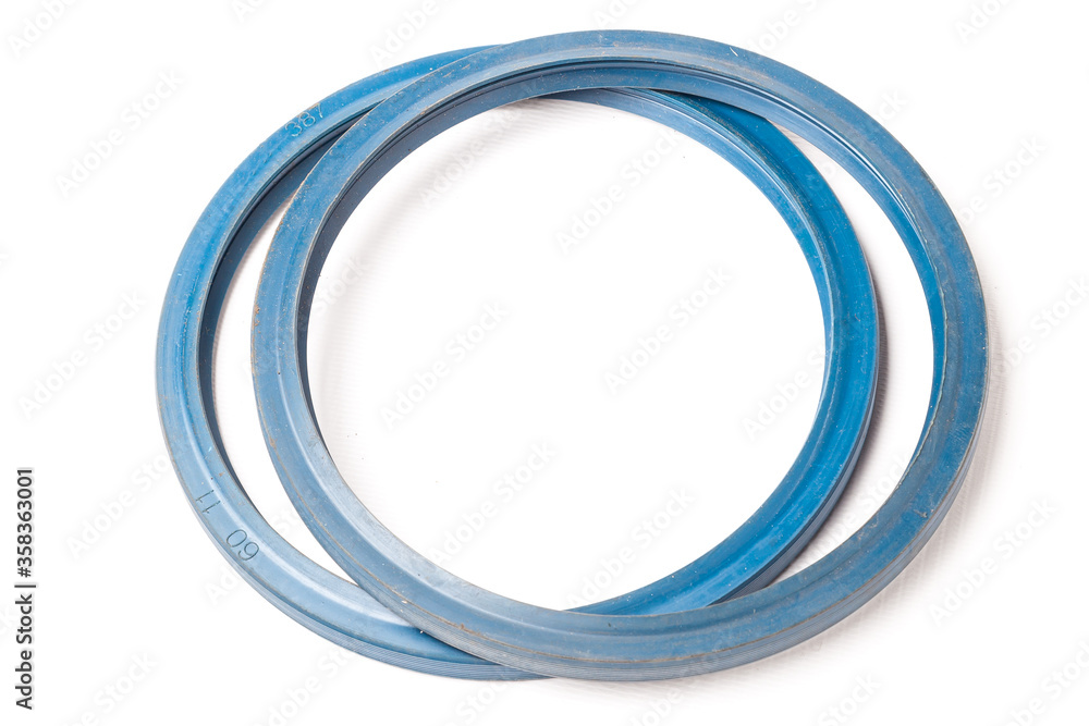 A pair of blue rubber sealing rings on a white isolated background in a photo studio for replacement when repairing a car or for sale when autoparsing. A pair of blue rubber sealing rings on a white isolated background in a photo studio for replacement when repairing a car or for sale when autoparsing.