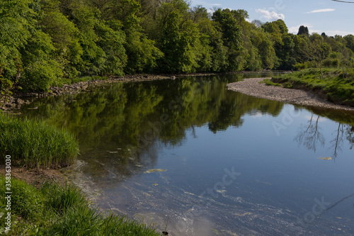 Summer day on the river ribble, Clitheroe. Gentle flowing water and lush green foliage 
