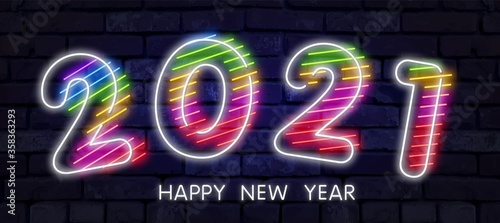 Colorful neon 2021 Happy New Year Neon banner. Realistic bright neon billboard on brick wall. Concept of holiday card with glowing text. 2021 Neon Text.