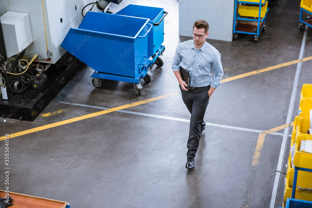 Businessman walking in factory Businessman walking in factory