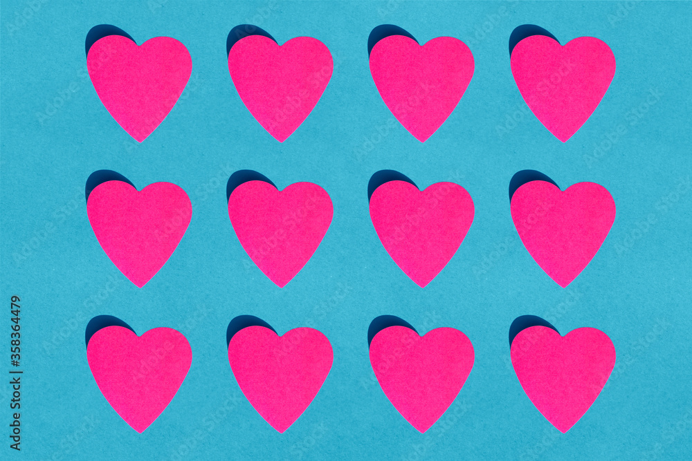 Pattern of pink paper hearts against blue background Pattern of pink paper hearts against blue background