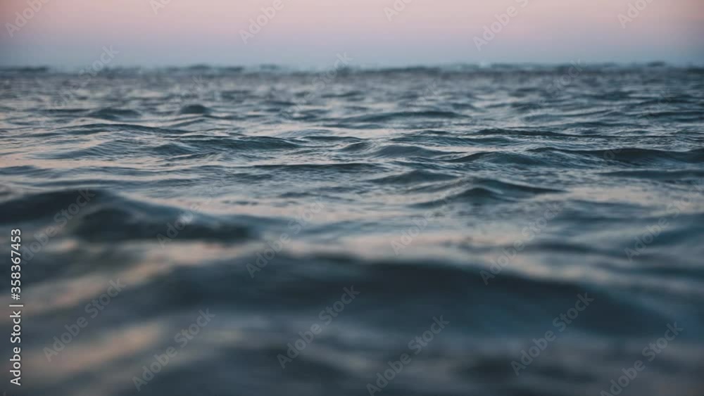 Sea wave in twilight evening close up, low angle view, sunrsie shot, Disturbed dark blue ocean water. Slow motion Sea wave in twilight evening close up, low angle view, sunrsie shot, Disturbed dark blue ocean water. Slow motion