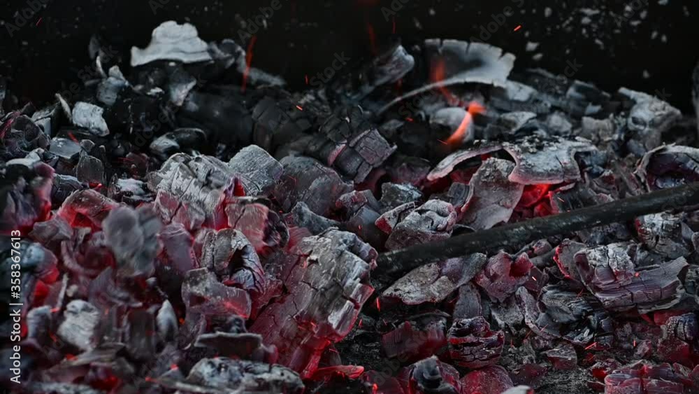 slow stirring of hot coals with a poker on the grill slow stirring of hot coals with a poker on the grill