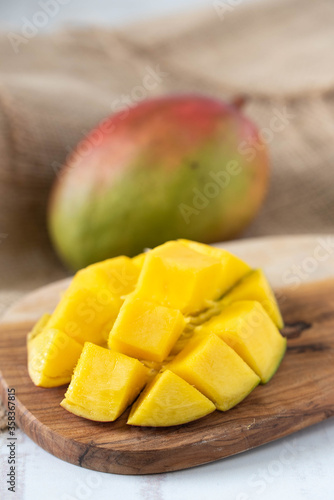 whole and cutted mango on wooden background
