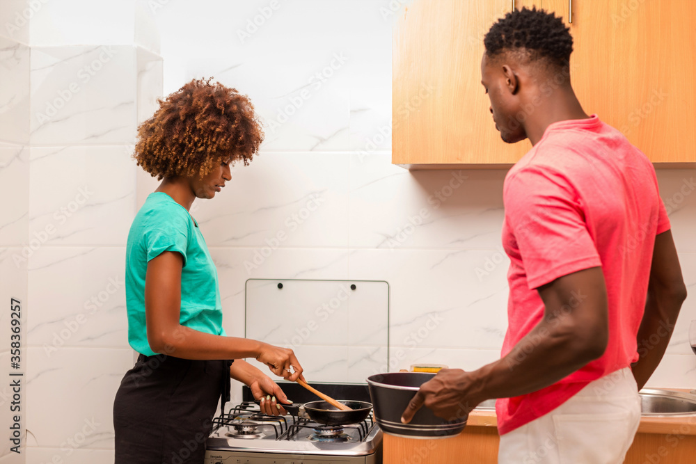 Obraz premium Black African American couple preparing food in the kitchen