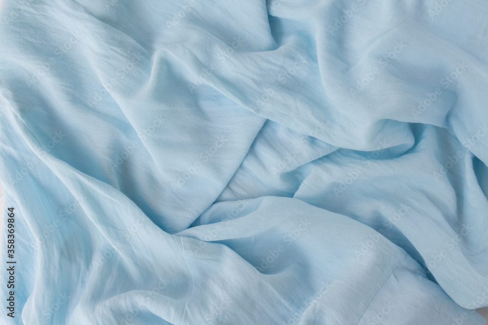 Obraz premium Flat lay modern abstract background blue fabric. Natural blue texture in beautiful folds. Blogger concept, Top view