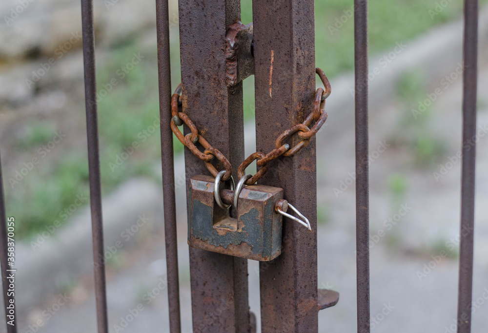 Padlock. Iron chain on the fence. Iron gate. Padlock. Iron chain on the fence. Iron gate.