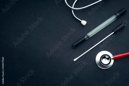 Medical swab and stethoscope closeup on black background. Health care and copy space concept