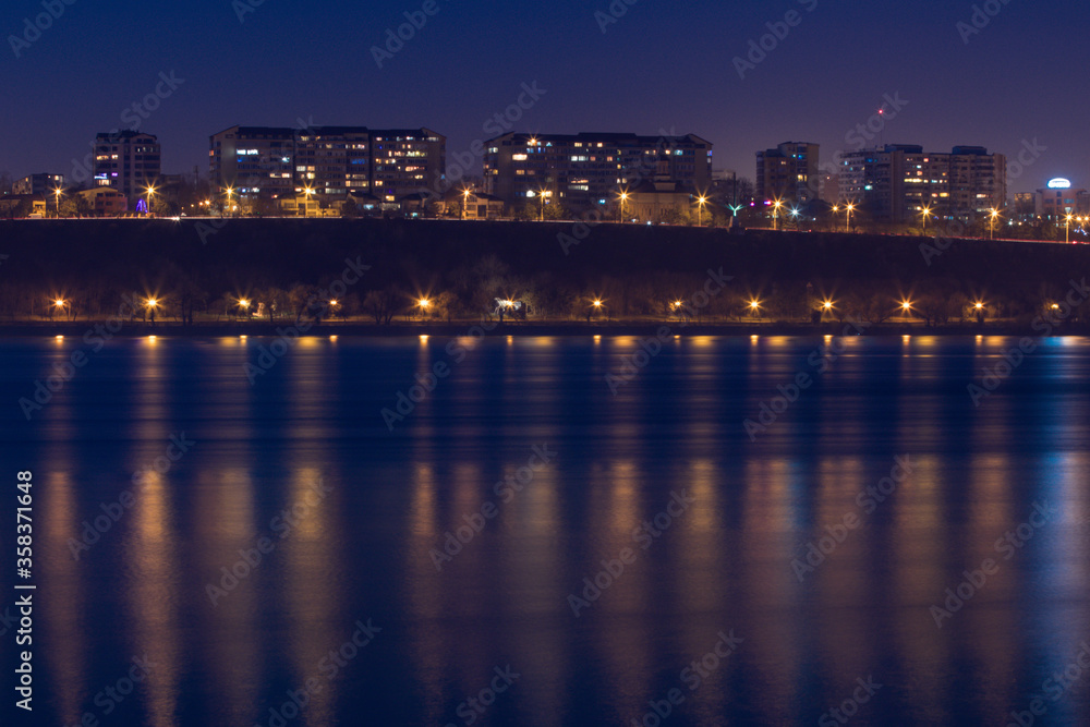 Cityscape of town Galati on Danube river from shore of Braila County, Romania at sunset