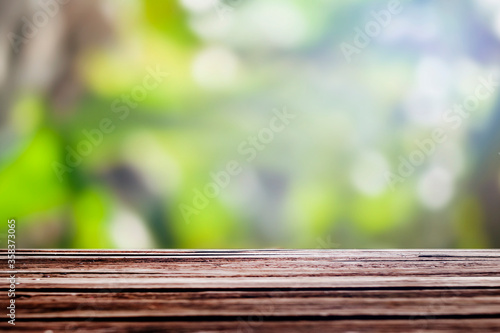 Wood floor with blurred trees of nature park background