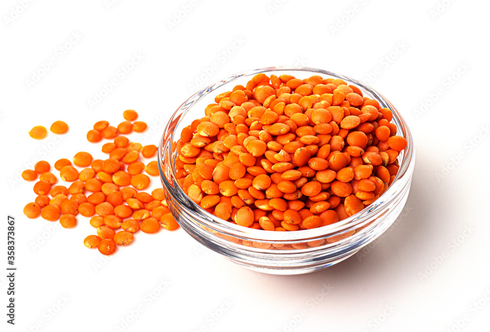 A pile of raw red lentils in a glass container, isolated on a white background. useful product A pile of raw red lentils in a glass container, isolated on a white background. useful product