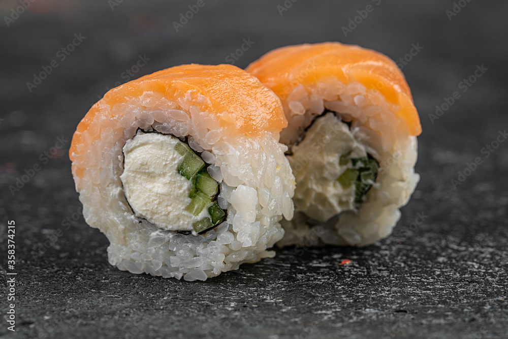Beautiful Philadelphia Sushi Rolls Set with Salmon and Cream Cheese and Cuccumber on Black Slate Plate Close Up. Uramaki, Nori Maki or Futomaki Sushi with Trout Fillets, Soy Sauce and Wasabi Beautiful Philadelphia Sushi Rolls Set with Salmon and Cream Cheese and Cuccumber on Black Slate Plate Close Up. Uramaki, Nori Maki or Futomaki Sushi with Trout Fillets, Soy Sauce and Wasabi