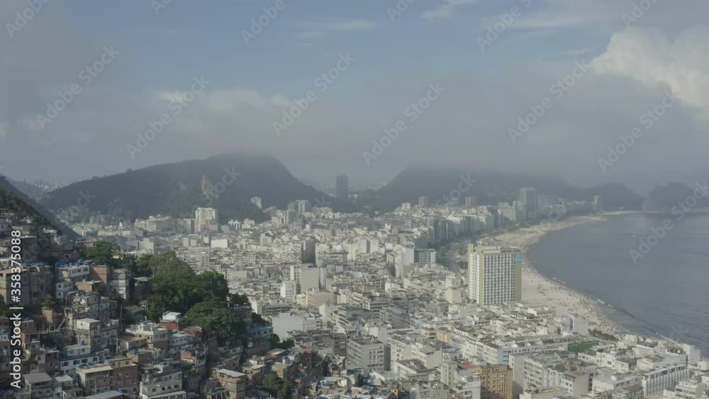 Drone, aerial shot of favelas on the hills of Rio de Janeiro Brazil with Copacabana in the background Drone, aerial shot of favelas on the hills of Rio de Janeiro Brazil with Copacabana in the background
