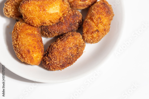 close-up aerial view of several crispy homemade croquettes served on a white plate