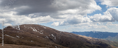 Panoramic view of Midzor summit and Old mountain highlands at the end of winter with come remaining snow and cloudy sky