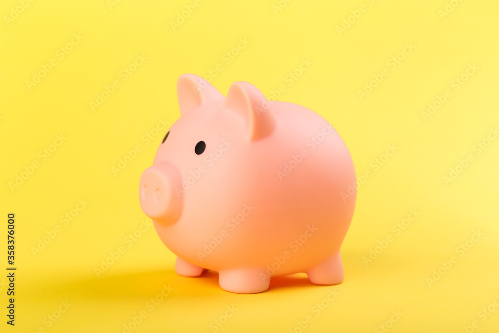 pink piggy bank on a yellow background. Concept of saving money or savings, investment.