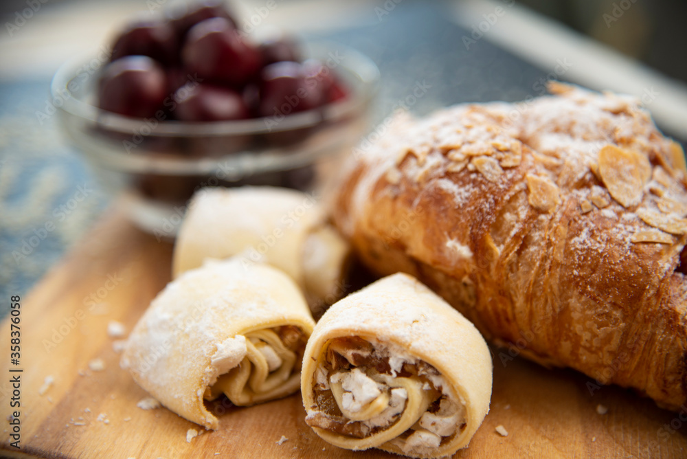 Close-up of cakes on a background of croissant and cherry Close-up of cakes on a background of croissant and cherry