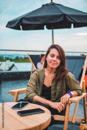 young gorgeous woman sitting in cozy chair at outdoors cafe © phpetrunina14