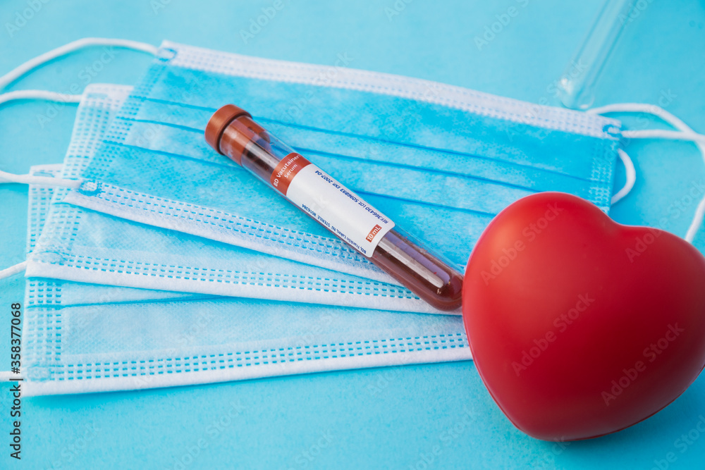 a top view of a coronavirus blood test tube and a mask , a world and a red heart a top view of a coronavirus blood test tube and a mask , a world and a red heart