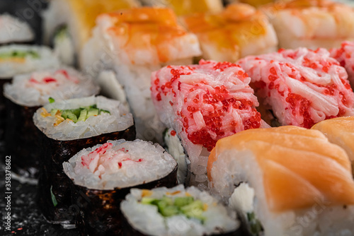 Traditional Japanese food - sushi, rolls and sauce on grey metal background. Top view