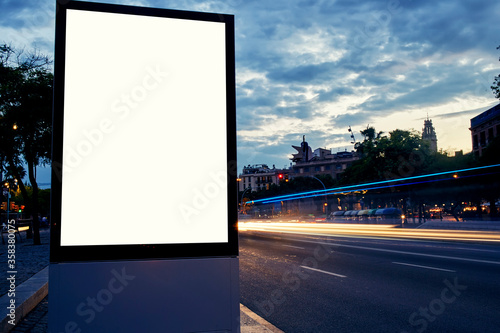 Illuminated blank billboard with copy space for your text message or content, public information board in night city with beautiful dusk on background, advertising mock up banner in metropolitan city