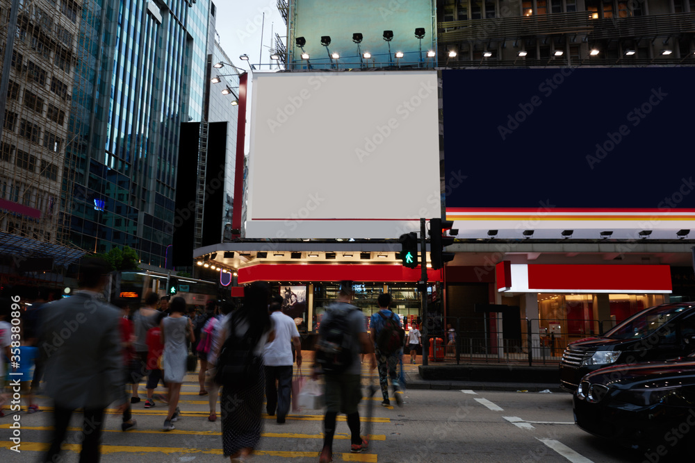 Naklejka premium Publicity mock up area for advertising or commercial information Lightbox on exterior of modern buildings in downtown, blank billboards with copy space on skyscraper facade, people at crosswalk